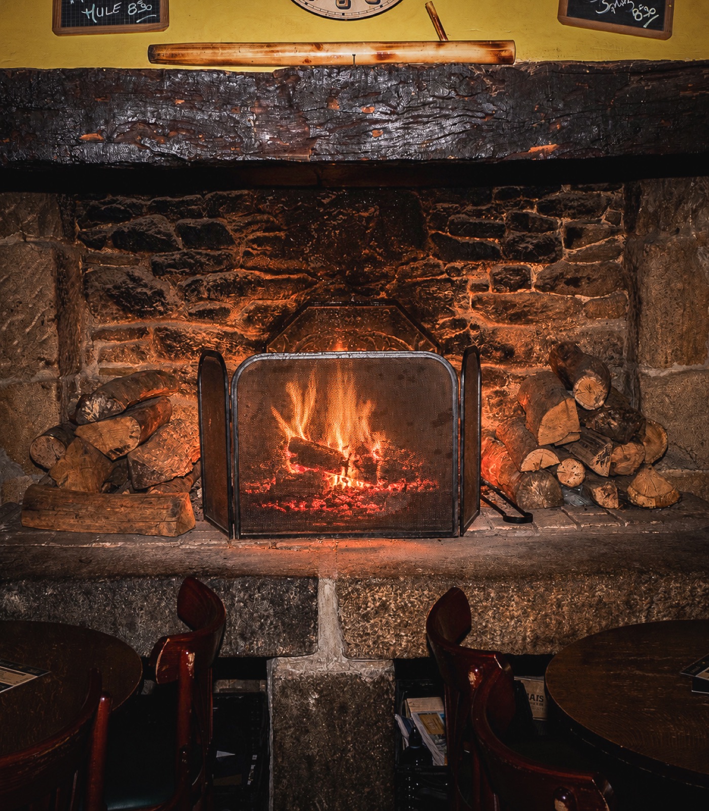 Cheminée en pierre avec feu de bois dans le pub